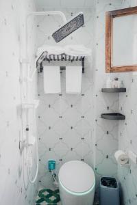 a white bathroom with a toilet and a sink at 一千零一夜喀什古城民宿 Kashgar Ancient City Scenic Area in Kashgar
