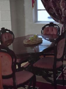 a dining room table with two chairs and a wooden table with at Historic Manor in Bridgetown