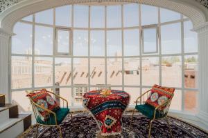 a room with two chairs and a large window at 一千零一夜喀什古城民宿 Kashgar Ancient City Scenic Area in Kashgar