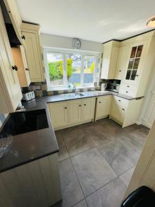 a kitchen with white cabinets and a sink at Moogara in Gorran Haven
