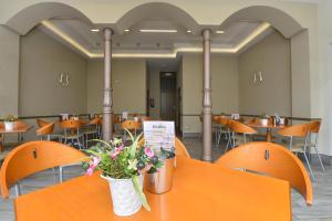a cafeteria with orange tables and chairs with flowers on them at Hostal Linares in Ribadeo