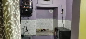 a small kitchen with a stove and a microwave at The Grasshopper's nest in kolkata