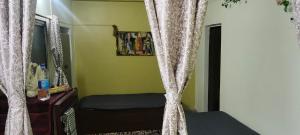 a bedroom with a bed and curtains in it at The Grasshopper's nest in kolkata