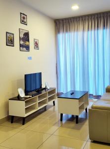 sala de estar con TV y sofá en Trefoil Studio Unit Setia Alam, en Shah Alam