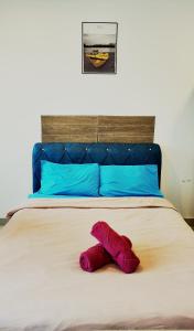 un animal de peluche púrpura tirado en una cama en Trefoil Studio Unit Setia Alam, en Shah Alam 3 fotos más