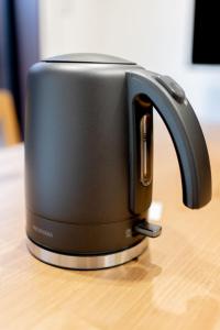 a black toaster sitting on top of a wooden table at JPRESERVE Hachijoguchi in Kyoto