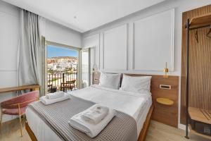 a bedroom with a bed with two towels on it at Eclectic Syros in Ermoupoli