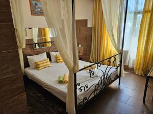 1 dormitorio con cama con dosel y cortinas amarillas en Paralax Hotel, en Varna 186 fotos más