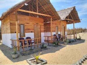 a wooden house on the beach with chairs at Arugam Bay Beach Morea in Arugam Bay