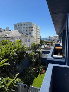 a balcony with plants and a view of a city at Cape Town Apartment, Sea View in Cape Town