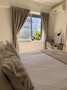 a bedroom with a bed and a window at Cape Town Apartment, Sea View in Cape Town