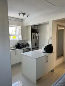 a kitchen with white cabinets and a white counter top at Cape Town Apartment, Sea View in Cape Town