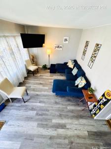 a living room with a blue couch and a flat screen tv at Niagara View at LaSalle SH in Niagara Falls