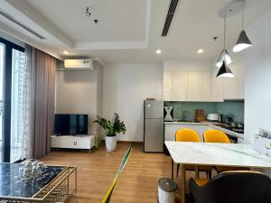 a kitchen with a table and yellow chairs in a room at Royal City Apartment Ha Noi by Luxe Hospitality in Hanoi