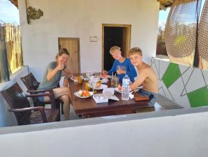 a group of people sitting at a table eating food at Arugam Bay Beach Morea in Arugam Bay