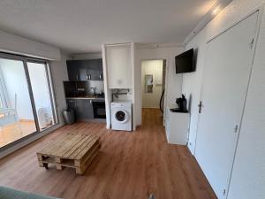 un salon avec une cuisine et une laveuse et une sécheuse dans l'établissement HELiOS, au Cap d'Agde