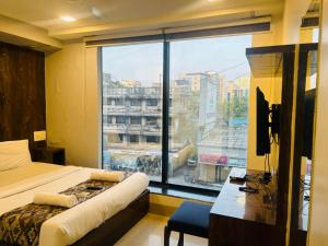a bedroom with a bed and a large window at Hotel Summer Inn in Mumbai