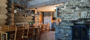 a kitchen and dining room with a stone fireplace at Kelokantola by the lake in Ruka
