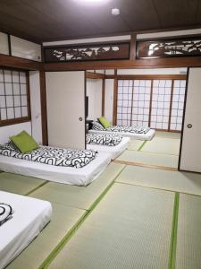 大阪Nippori Osaka Nishi-Tengachaya Guesthouse西天下茶屋アパートメント的窗户房间里一排床 更多37张照片