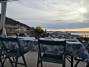 a table with glasses of wine on a balcony at La terrazza sul mare in Letojanni