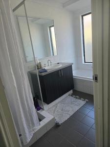 a bathroom with a sink and a mirror at Baldivis Basic Apartment in Baldivis