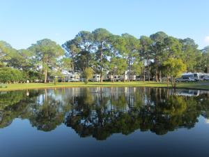 un lago en un parque con árboles en el fondo en Southern Palms Park Model 4 en Fort Mason