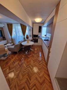 Una sala de estar con una mesa y una cocina. en Central 17, en Târgu Mureș