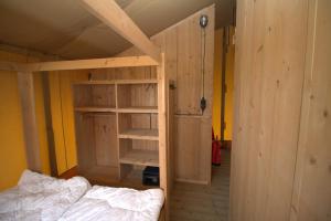WolphaartsdijkGlamping De Zuidvliet Nr 9的一间有双层床、一张床和一个衣柜的房间