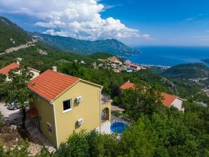 a yellow house with a view of the ocean at Golden Horizon Villas in Budva
