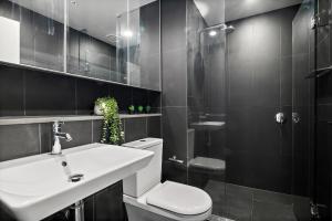 墨尔本High-Rise 2BR Luxury Apartment NYC-Inspired Design with Pool Gym Parking and Waterfront Views的配有白色马桶和水槽的浴室