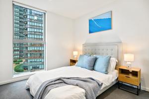 墨尔本High-Rise 2BR Luxury Apartment NYC-Inspired Design with Pool Gym Parking and Waterfront Views的带一张床和两扇窗户的卧室