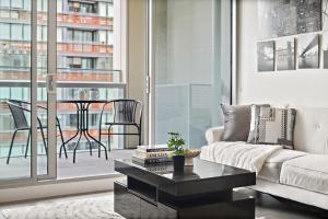 墨尔本High-Rise 2BR Luxury Apartment NYC-Inspired Design with Pool Gym Parking and Waterfront Views的带沙发和桌子的客厅 更多10张照片