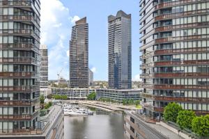 墨尔本High-Rise 2BR Luxury Apartment NYC-Inspired Design with Pool Gym Parking and Waterfront Views的两座高楼之间的河流景观