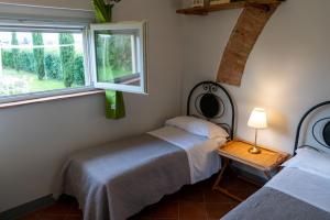 a bedroom with two beds and a window at Podere Bellavista - Agriturismo Bella Valle in Vada