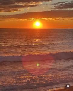 a sunset on the beach with a heart shaped wave at Casa Orchidea - Vista Mare meravigliosa in Bonassola +19 photos