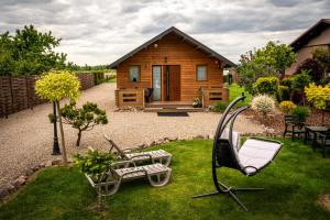 a garden with a house with a swing and a cabin at Relax domki Zator in Zator