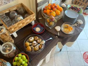 a table with a bunch of fruits and baskets of food at Bed and Breakfast Villa Giovanna in Rimini +71 photos