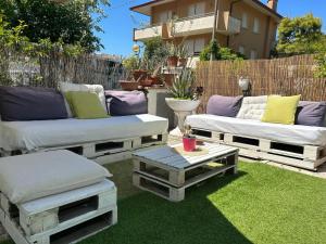 een patio met twee banken en een tafel op het gras bij Bed and Breakfast Villa Giovanna in Rimini