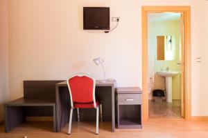 a desk with a red chair in a room at Hotel Casa Marzo in Cariñena