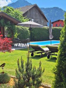 a pool with two lounge chairs and an umbrella at Denggnhof in Münster