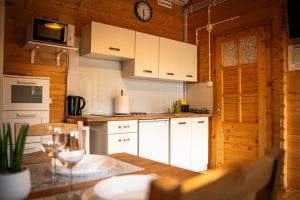 a kitchen with white cabinets and a clock on the wall at Relax domki Zator in Zator +9 photos