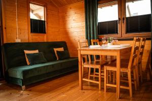 a dining room with a table and a couch at Relax domki Zator in Zator