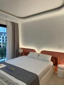 a bedroom with a large bed and a balcony at Sunny Hotel in Ðố Sơn