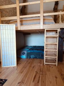 a bunk bed in a room with a wooden floor at Location gîte palette et papillons en Dordogne in Sainte-Eulalie-dʼAns