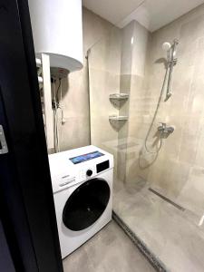 バトゥミにあるBatumi View Apartmentsのシャワー付きのバスルームにある洗濯機