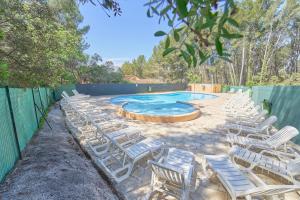 a group of chairs sitting around a swimming pool at Studio pour 4 au calme avec piscine et parking in Sanary-sur-Mer