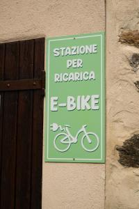 a sign on a wall with a bike on it at La Meira di Lucia B&B in Rossana