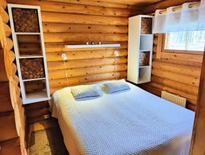 una camera da letto con un letto in una cabina di legno di Ainola Cottage ad Alapitkä
