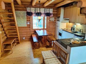 una cucina in una baita di tronchi con bancone e tavolo di Ainola Cottage ad Alapitkä Altre 66 foto