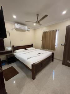 a bedroom with a large bed and a fan at Rio Grande ApartHotel in Madurai